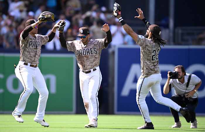 San Diego Padres left fielder Juan Soto (left), center fielder Trent Grisham (center) and right fielder Fernando Tatis jump up and put their hands in the air in celebration